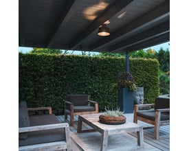 SLV PHOTONI loftlampe monteret på overdækket terrasse ved kystnære områder, belyser et udendørs siddeområde.