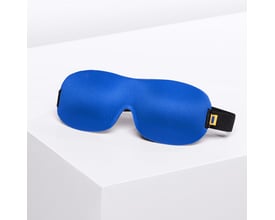 Travel Blue Ultimate sovemaske i blå med justerbar sort strop, præsenteret på en hvid, minimalistisk piedestal.