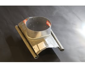 Nærbillede af Kierulff Metalbestos skorstenens fleksible tagrygsbeslag med 230mm diameter, vist med trykt vejledning på folien.