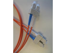 Orange fiberoptisk patchkabel med SC/PC duplex konnektorer, mærket A og B, forbundet i et netværksmiljø.
