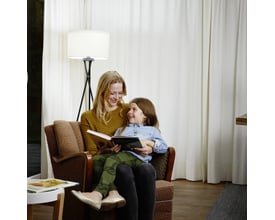 Ledvance LED standard Ra97 lyskilde monteret i en gulvlampe oplyser en kvinde og et barn, der læser sammen i en stue.