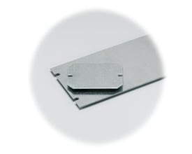 Fibox monteringsplade D-MP i aluzink, 54x140x1,5 mm, vist med en mindre plade ovenpå, med lette hakker i kanten.