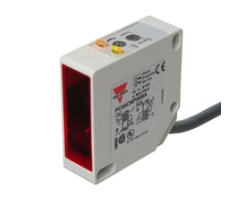 Carlo Gavazzi fotoaftaster PC50CNP06BA med rød frontflade og kabel, set skråt forfra med justeringsknapper på toppen.