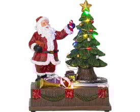 Star Trading Kidsville juleby med detaljeret julemand ved et lysende juletræ, dekoreret med gaver og horn på en piedestal.