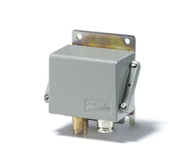 Danfoss CAS pressostat i grå farve, vist fra en vinkel, med synlige tilslutninger og et Danfoss logo på siden.