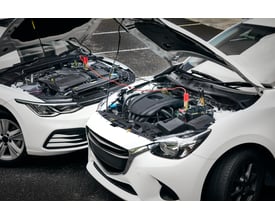 Osram startkabler forbinder to hvide biler med åbne motorhjelme, viser tilslutning til batterier.