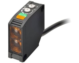 Omron lysbom med reflektor, tasteafstand 7000 mm. Viser enheden med justeringsknapper, LED-indikator og tilslutningskabel.