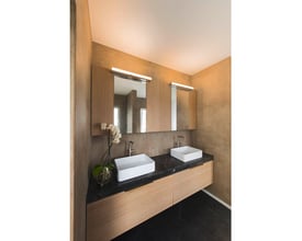 SLV MARYLIN LED væglampe monteret over et badeværelsesmøbel med to håndvaske og spejle.