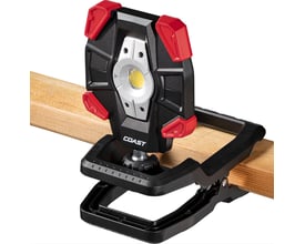 Detalje af Coast CL40R arbejdslampe med clip-fod fastgjort til en træbjælke, med synlig LED-lyskilde.