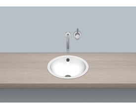 Detalje af Alape EB.K400 håndvaskens indre med overløb, installeret i en træbordplade med et minimalistisk armatur.