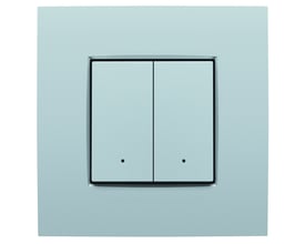 Niko 2-tryk med integreret komfortsensor i sølvfinish, vist på en lys væg uden ramme.