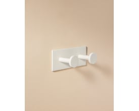 Cosmic Double Hook i mat hvid, monteret på en beige væg, viser dens minimalistiske design og funktionelle dobbeltkrog.
