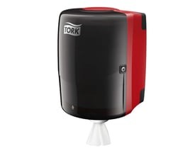 Tork Maxi Centerfeed dispenser i sort og rød med Tork logo, dispenserer hvidt aftørringspapir forneden, på hvid baggrund.