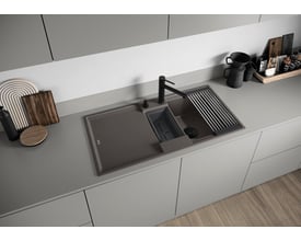 BLANCO alta-s ii køkkenarmatur i sort mat, monteret på en grå bordplade med en undermonteringsvask og en udtræksbruser. Tilbehør som rullebakke og sæbedispenser ses også.