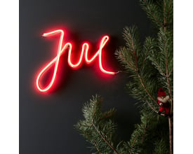 Rød Markslöjd New York Deco Jul Ledtube monteret på mørk væg ved siden af en grankvist med en lille nisse.