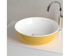 Detaljebillede af Villeroy & Boch Artis håndvask i gul BiColour med hvid inderside og et hvidt bundventil, set fra siden.
