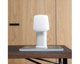 SACKit Base London lampefod i hvid stål, monteret med en hvid lampeskærm og placeret på en bog på et bord.