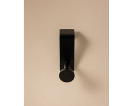 Cosmic håndklædekrog i mat sort finish, viser krogens moderne design med diskret cirkulær afslutning på en lys baggrund.