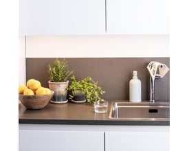 Markslöjd Combine skinne på 100 cm i hvid aluminium med integreret LED-lys, monteret over en køkkenbordplade.