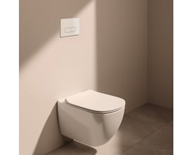 Ideal Standard væghængt toilet i hvid monteret på en lyserød væg, med lukket toiletsæde og skylleknap.