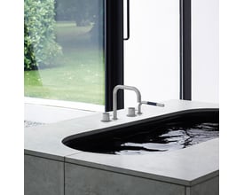 Vola SC10-16 krom vandhane med 2-grebs betjening monteret i karkanten på et moderne badeværelse med udsigt til grønne områder.