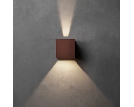 Lumenlight Toscana væglampe i corten monteret på en væg med varmt lys kastet opad og nedad.
