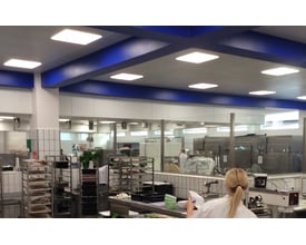 SG Armaturen Sense Eco LED-panel på 600x600 mm monteret i loftet i et industrielt køkkenmiljø med blå bjælker.