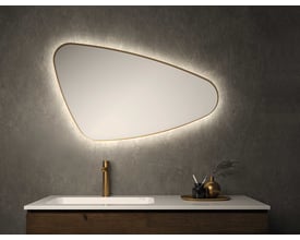 Sanibell INK SP23 organisk spejl 100x60 cm med mat guld aluramme og integreret baggrundsbelysning på en grå væg.