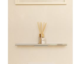 Cosmic Architect S+ badeværelseshylde i krom med en duftspreder med pinde og glasflaske placeret på den.