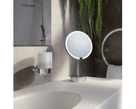 Smedbo Home sæbedispenser i poleret krom med matteret glasbeholder monteret på væggen ved siden af en vask.