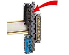 Legrand universalholder til terminal blok monteret på DIN-skinne med klemrækker og en blå komponent.