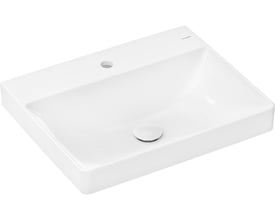Isoleret billede af Hansgrohe Xelu Q håndvask, viser det midterplacerede hanehul og den polerede bundventil på den hvide porcelænsoverflade.
