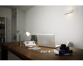 Osram LED LINE klar lyskilde monteret i en moderne væglampe over et arbejdsbord med laptop og kamera.