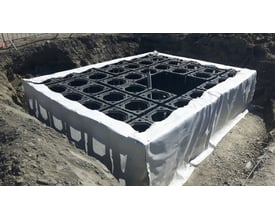 Combigrid geotekstil, 2,5 x 50 m, 310 g, installeret i en udgravning til at stabilisere et modulopbygget system.