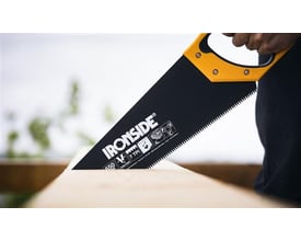 Ironside håndsav med sort 550 mm klinge og gult håndtag bruges til at save i et stykke træ.