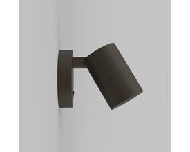 Astro Ascoli single spot lampe i bronze monteret på en lysegrå væg, vist fra siden med lampens justerbare kipfunktion.
