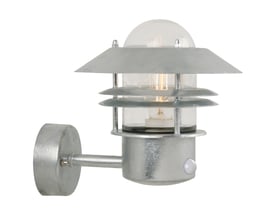 Nordlux Blokhus væglampe i galvaniseret finish med klar glas og sensor, vist isoleret på hvid baggrund.