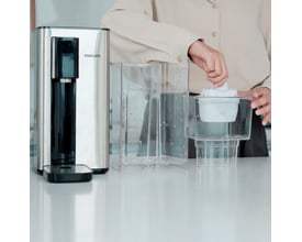 Philips vandedispenser ADD5906S/10 i rustfrit stål med en person, der isætter et filter i vandtanken.