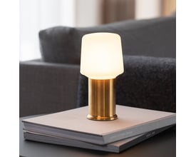 SACKit Base London lampefod i messing finish, brugt som del af en bordlampe med hvid skærm, placeret på en stak bøger.