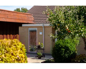 Grå Plastmo tagrende monteret på en gul murstensbygning med brune tegltage.