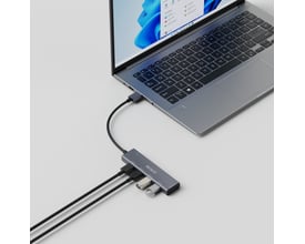 Deltaco USB-A hub i grå aluminium med fire USB 3.0 porte tilsluttet en bærbar computer, med to USB-enheder indsat.
