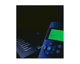 Grundfos kontrolpanel CU 300 med grøn skærm og betjeningsknapper, samt en liste over advarsler på sort baggrund.