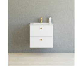 Dansani Button greb i messing med sort finish, vist på et hvidt møbel med en messingvandhane og grå væg.