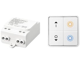 Lauritz Knudsen DALI modtager med trådløst 4-tryk, vist med den hvide modtager på venstre side og et hvidt 4-tryk med lyssymboler på højre side.