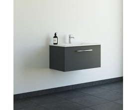 Dansani Mido+ møbelpakke monteret på en hvid væg over et mørkt klinkegulv, viser den 81 cm brede mat grå skuffe og hvide porcelænsvask.
