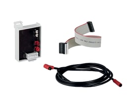 Geberit Mera/Sela interface 12 V DC, vist med et hvidt interface-modul, et fladt gråt kabel og et sort strømkabel med røde stik.