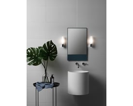 Astro Lighting Bari spejllampe i krom monteret på en lysgrå, flisebelagt væg ved siden af et spejl og en håndvask. Inkluderer glasdetaljer.