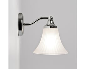 Astro 0506 Nena væglampe i krom, monteret på en hvid væg, med en hvid opal skærm og G9 fatning.