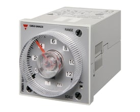 Carlo Gavazzi multifunktionstidsrelæ med gråt hus og stor frontdrejeknap med rød viser til tidsindstilling.