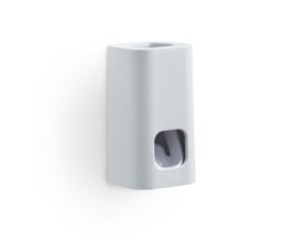 HeFe SEVENTY tandpastadispenser i hvid plast, vist fra siden monteret på en hvid væg.